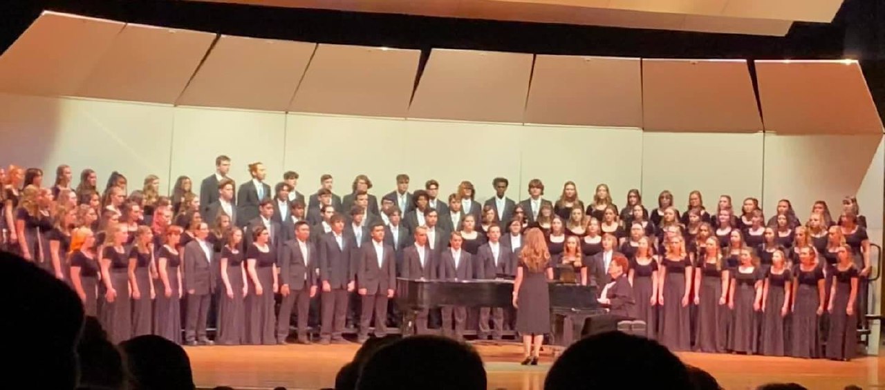 Ashley conducting a large choir